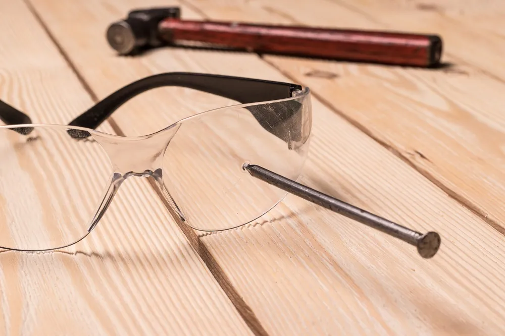 Nail stuck in safety glasses. Personal protective equipment and